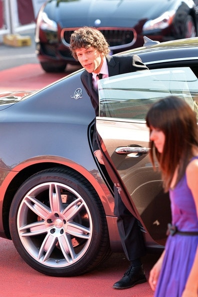 Jesse Eisenberg getting out of his black Maserati in his Tuxedo